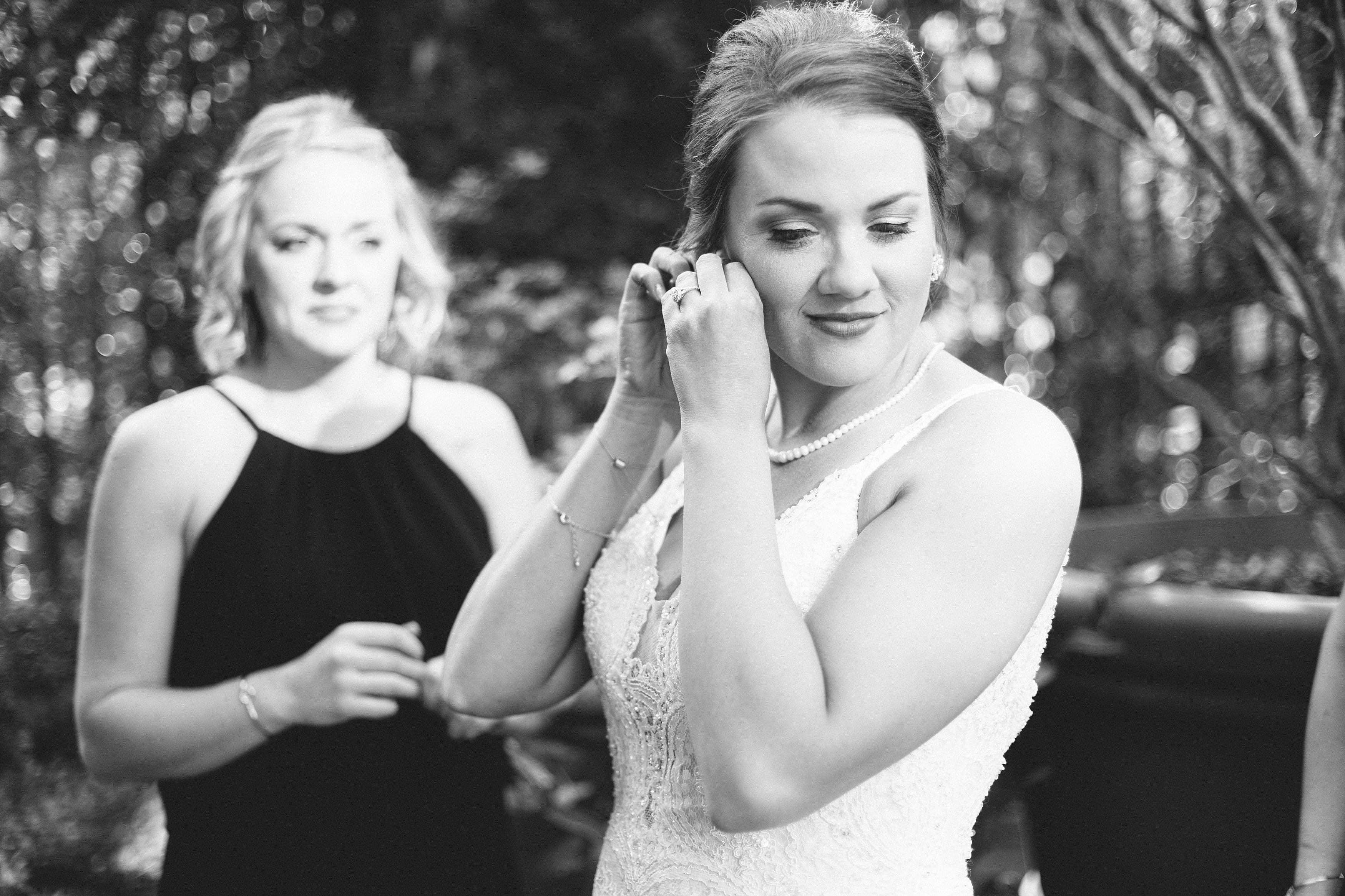 Bride putting in earrings on wedding day.